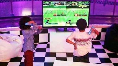 Sheikh Hamdan bin Saeed bin Hamdan Al Nahyan on the left, playing tennis on a Wii console with a friend at the Sheikh Mohammed bin Saeed bin Hamdan Al Nahyan tennis tournament on Friday. Delores Johnson / The National