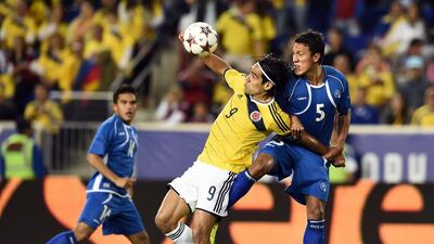 Colombia forward Radamel Falcao, centre, vies for the ball with El Salvador defender Alexander Mendoza during an international friendly at Red Bull Arena in Harrison, New Jersey, on October 10, 2014. Jewel Samad / AFP