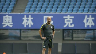 Manchester City manager Pep Guardiola watches his team’s training session at the Olympic Sports Center Stadium in Beijing, Sunday, July 24, 2016. Mark Schiefelbein / AP Photo
