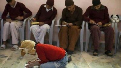 A 10-year-old former drug addict, centre,adds colours to a drawing with recovering drug addicts in a classroom at the Dost Foundation in Peshawar.