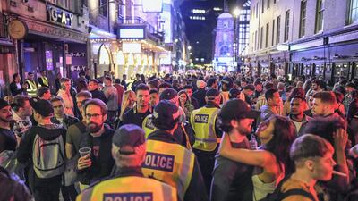 Police officers are seen walking through heavy crowds in Soho on July 4 in London. Getty Images