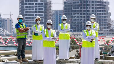 Khaled Khamees Almarzooqi (right, front row), head of Environment, Health and Safety Department and his team at the site in Al Raha Gardens. Victor Besa / The National