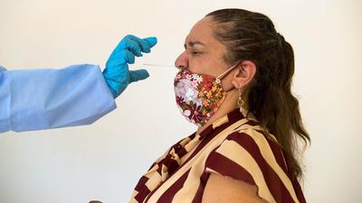 A public health official collects swab for the coronavirus test at the Venezuelan embassy in Santo Domingo, Dominican Republic. EPA