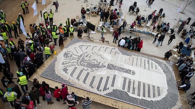 People gather around a depiction of ancient Egyptian pharaoh Tutankhamun's death mask made from coffee cups outside the Grand Egyptian Museum (GEM), in Giza, Greater Cairo, Egypt, 28 December 2019. EPA