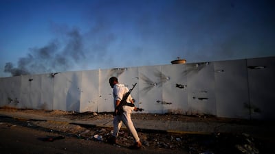 A Libyan rebel walk past a damaged metal fence as they overrun Libyan leader Moamer Kadhafi's fortified Bab al-Azizya headquarters in the capital Tripoli after heavy fighting on August 23, 2011. AFP PHOTO/FILIPPO MONTEFORTE *** Local Caption *** 666076-01-08.jpg