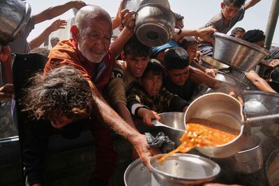 Palestinians desperately try to obtain donated food at a community kitchen in Khan Younis on Sunday. AP