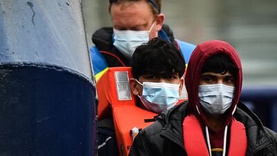 A UK coastguard helps migrants get off the UK Border Force vessel 'Alert' after they were picked up attempting to cross the English Channel. AFP