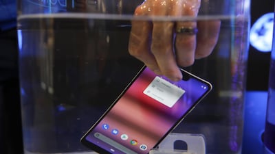 A smartphone is submerged in water to demonstrate liquid repellent nanotechnology on the P2i stand on day two of the MWC Barcelona. Bloomberg