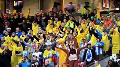 Wigan fans in fancy dress cheer on their side in the stands on Boxing Day.