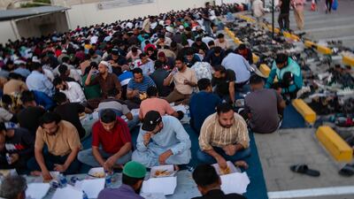 Men sit with iftar meals outside Al Farooq Omar bin Al Khattab Mosque to break the day's fasting. Antonie Robertson / The National