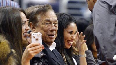 Los Angeles Clippers owner Donald Sterling, center, and V. Stiviano, right, watch the Clippers play the Sacramento Kings earlier in the NBA season. The NBA is investigating a report of an audio recording in which a man purported to be Sterling makes racist remarks while speaking to Stiviano. AP Photo/Mark J. Terrill