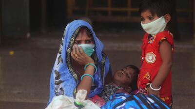 A woman and her children wait for a train at Lokmanya Tilak Terminus in Mumbai, India, on April 7, 2021. Mumbai and dozens of other cities have imposed night-time curfews to counter a rise in coronavirus infections. AP
