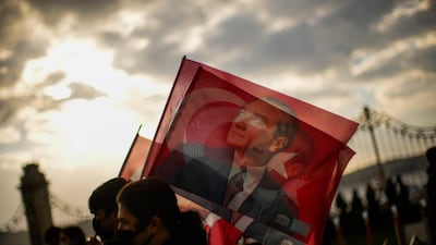 People hold Turkish flags as they pay tribute to Turkey's founding father Mustafa Kemal Ataturk, at Dolmabahce palace in Istanbul, Turkey, on November 10, 2021. AP