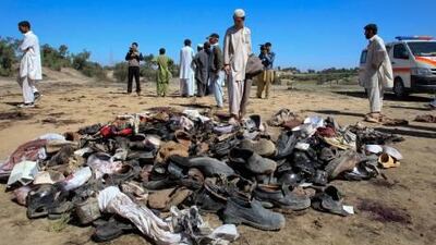 A man stands next to sandals left after a Taliban suicide bomber attacked a funeral in northwest Pakistan, killing 37 people.