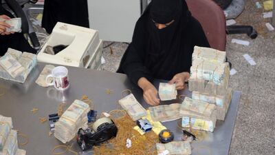 A bank teller counts money at the Central Bank of Aden in Yemen. AFP