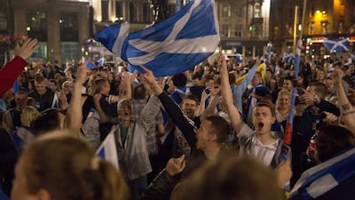 Supporters of the Yes campaign in the Scottish independence referendum cheer with Scottish Saltire flags as they await the result after the polls closed, in George Square, Glasgow, Scotland. Matt Dunham / AP Photo