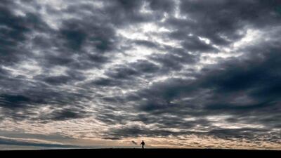 A villager crosses a field before the rain outside Moscow. AFP