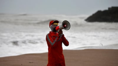 A member of the National Disaster Response Force appeals to fishermen to stay away from the shore as cyclone Tauktae bears down on Veraval in the western state of Gujarat. Reuters