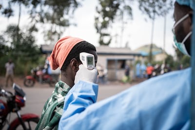 A health worker checks locals’ temperature as a preventive measure against Ebola yesterday in North Kivu, the Democratic Republic of Congo. EPA