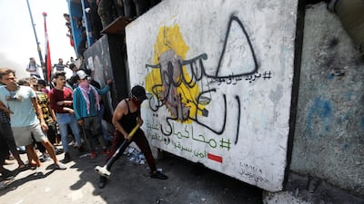 An Iraqi demonstrator tries to smash a concrete wall during ongoing anti-government protests after newly-appointed Iraqi Prime Minister Mustafa al-Kadhimi called for the release of all detained protesters, at Jumhuriya bridge in Baghdad, Iraq. REUTERS
