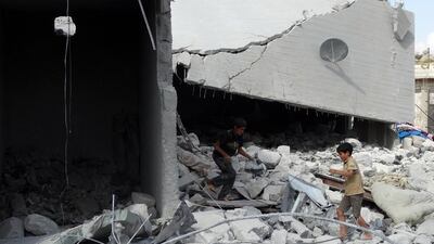 Syrian children check a damaged house, reportedly hit by US-led coalition airstrikes, in the village of Kfar Derian in the western Aleppo province on September 23. Sami ALi / AFP Photo