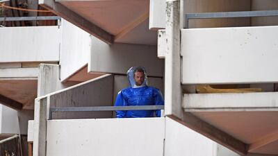 A German police officer in protective gear walks down stairs in an apartment building in Cologne, Germany, where a Tunisian suspect and his German wife were producing biological weapons for an attack in Germany. AP