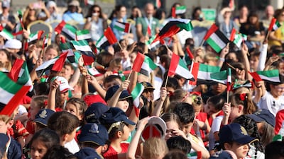 Pupils wave the national flags at Repton Al Barsha. Pawan Singh / The National
