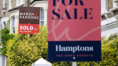 Estate agent signs outside residential properties in London. House price growth in the UK is expected to cool. Bloomberg