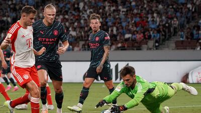 Bayern Munich goalkeeper Sven Ulreich pounces on the ball as Manchester City's Erling Haaland looks on. AFP
