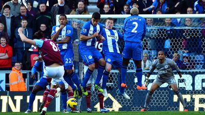 West Ham's loan striker Andy Carroll tries to find a way through the Wigan wall at The DW Stadium. Paul Ellis/AFP