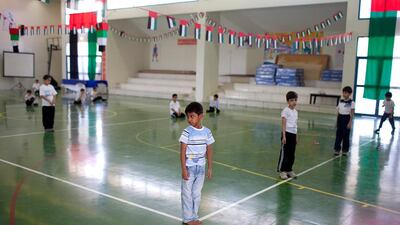Students at Al Ruwais Primary Boys School make room to exercise during a physical education class.