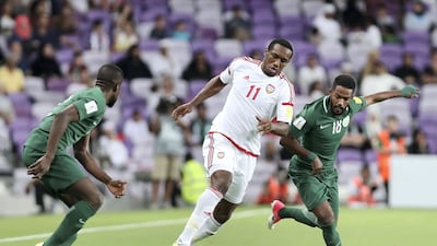 UAE's Ahmed Khalil, centre, beats Saudi Arabia's Nawaf Alabid, right, during their World Cup qualifier at Hazza bin Zayed Stadium on Tuesday. Chris Whiteoak / The National