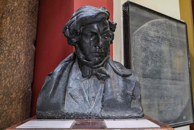 A bust of French scholar and philologist Jean-Francois Champollion, and behind, a replica of the Rosetta Stone on display at the entrance of the Egyptian Museum in Cairo. Photo: AFP