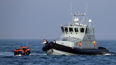 A Border Force vessel assists a group of people thought to be migrants on board from their inflatable dinghy in the Channel on Monday. PA via AP