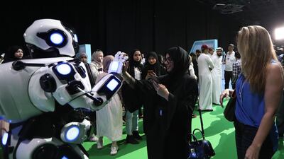 Visitors interact with a robot during a recent robotics conference in Dubai. Courtesy: EPA