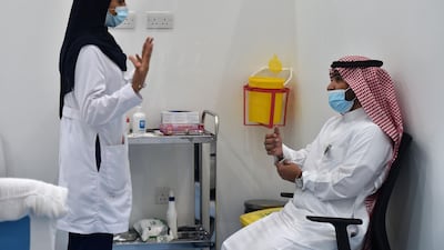 A nurse speaks to a man before administering the Pfizer-BioNTech COVID-19 coronavirus vaccine. AFP