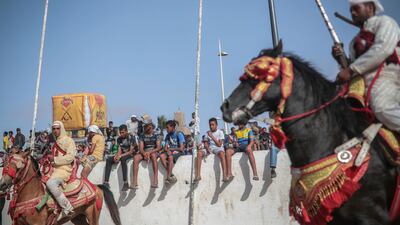 People watch as riders wait during Tabourida, a traditional horse riding show also known as Fantasia, in the coastal town of El Jadida, Morocco.