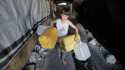 A child carries water containers in Jabalia, in northern Gaza, as supplies dry up. AFP