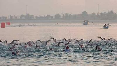 Competitors swim along the beaches of Corniche in the early morning start of the triathlon. The swimming festival starts tomorrow morning.