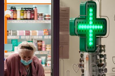 An elderly lady exits a pharmacy in Bucharest, Romania. AP