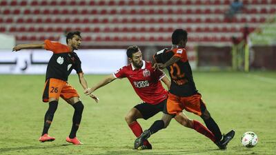 Al Ahli's Hugo Viana, centre, tries to defend the ball from Masoud Hassan of Ajman during their Arabian Gulf League match at Rashid Stadium in Dubai on September 29, 2014. Sarah Dea / The National