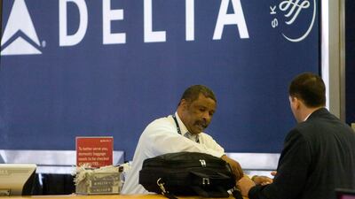 A Delta Air Lines ticket agent assists a passenger at Hartsfield Jackson Atlanta International Airport in the US. The company reported an 8 per cent year-on-year rise in net income to $1.1bn in the final three months of 2019. EPA
