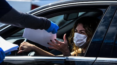A woman collects unemployment forms at a drive-thru collection point in Florida. Another 6.6 million US workers filed for unemployment benefits for the week ending April 4. Photo: AFP