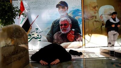 A woman reacts over the grave of Iraqi militia commander Abu Mahdi al-Muhandis during the one year anniversary of the killing of him and senior Iranian military commander General Qassem Soleimani in a U.S. attack, at the Wadi al-Salam cemetery, in Najaf, Iraq. Reuters