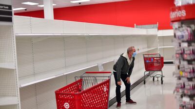A shopper wearing a face mask browses merchandise beside bare shelves due to the coronavirus pandemic at a Target store in King of Prussia, Pennsylvania. Reuters