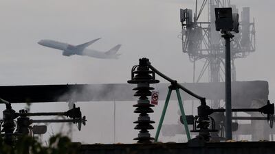 A plane takes off as smoke rises above an electrical substation a day after it caught fire and wiped out power at Heathrow Airport. Reuters