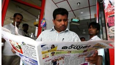 Latheef, from Kerala, reads a Malayalam newspaper to follow the election results from different states in India at a restaurant in Dubai.