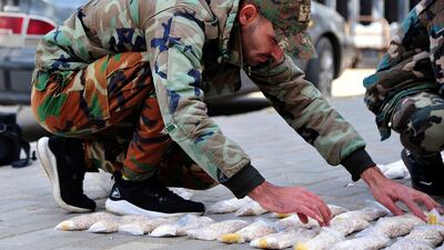 A Syrian officer examines seized Captagon pills. AP