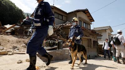 Japan's Maritime Self-Defense Force's personnel search for missing people with a search and rescue dog in Kure, Hiroshima Prefecture, western Japan, on July 12, 2018. EPA