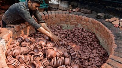 A potter arranges traditional earthen oil lamps in an oven at a workshop, ahead of Navratri on the outskirts of Ahmedabad. AFP